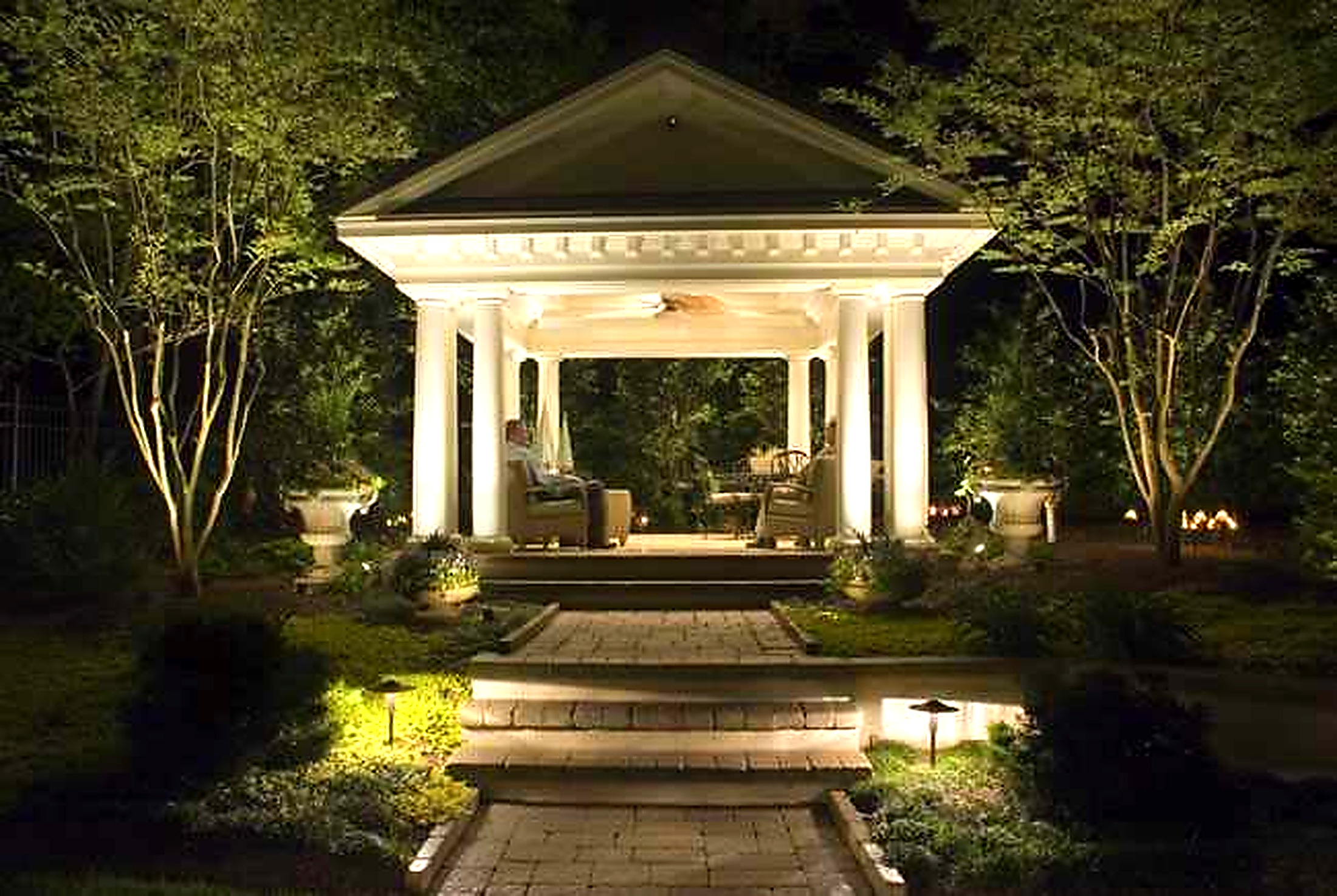 Pavilion entry framed by path lights and tree uplighting